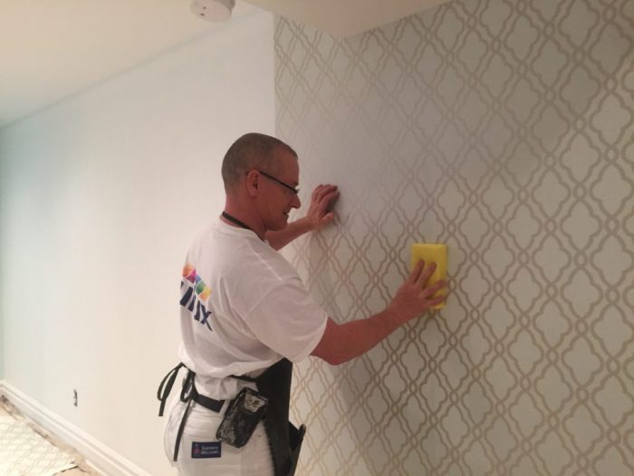 Peintre en batiment pose de tapisserie papier peint professionnelle.
